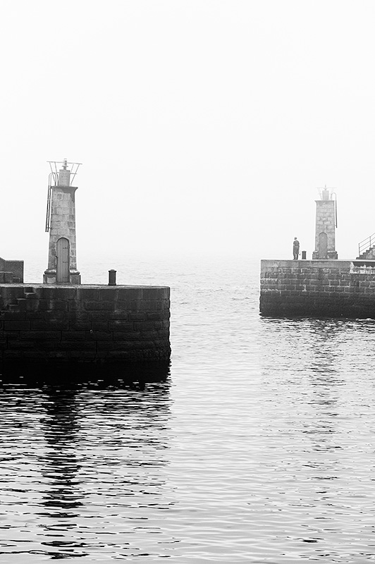 Fotografía en blanco y negro de la niebla a la entrada del puerto de Tapia de Casariego, en Asturias.