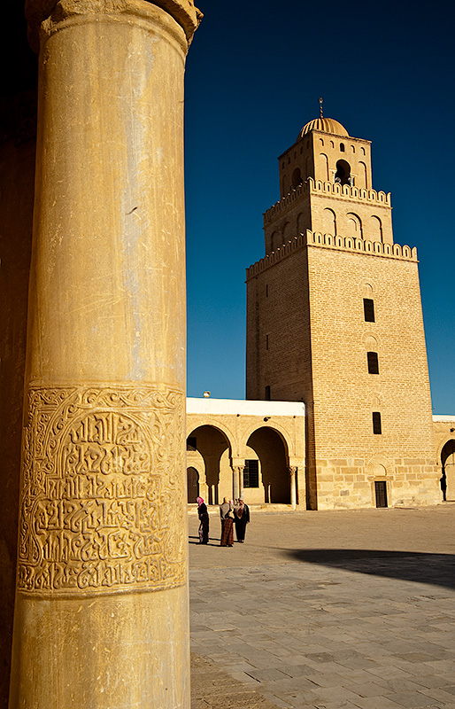 Dentro de la Gran Mezquita de Kairouan en Túnez, mezquita con patio y tres hombres.