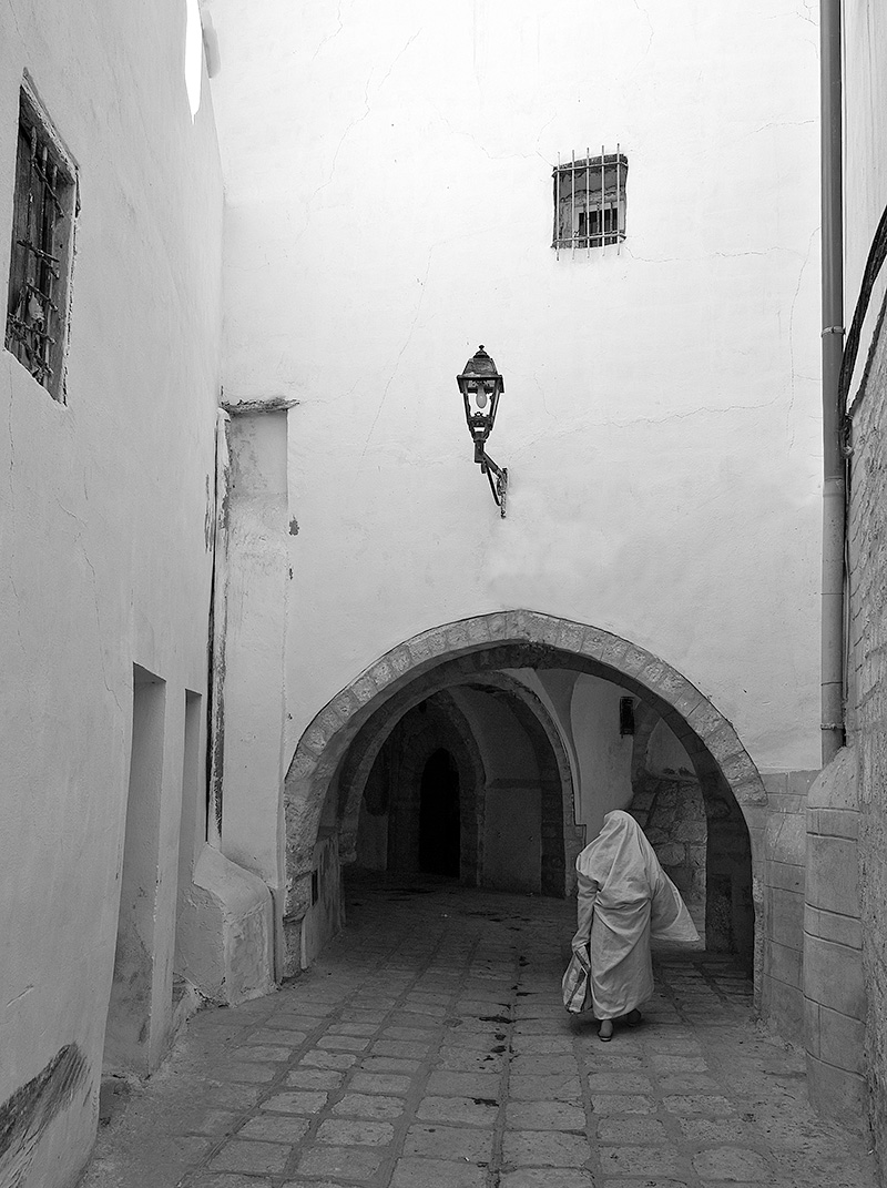 Calle con arcos y mujer en la medina de Túnez
