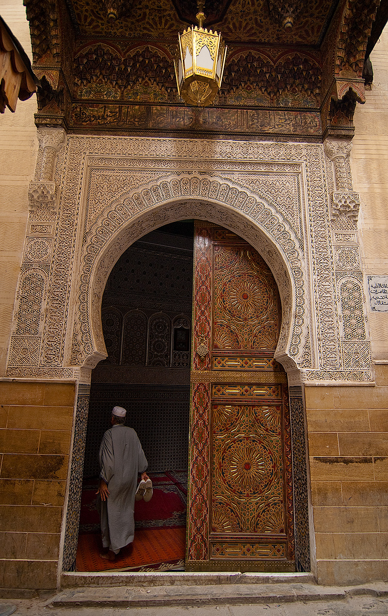 Puerta decorada con hombre entrando en la medina de Fez en Marruecos