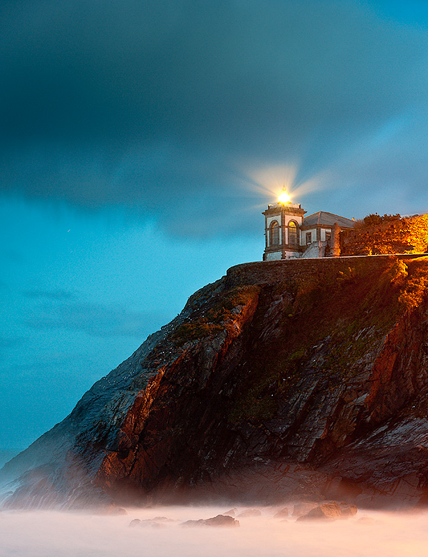 Atardecer en el faro, al borde del acantilado que cierra el puerto de Luarca. Asturias.