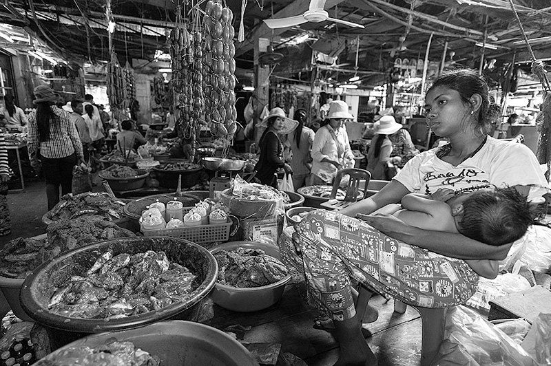 Mujer amamantando un niño en el mercado de Nom Pem. Camboya.